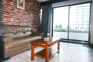 a living room with a couch and a coffee table at Collection O Luna Hotel Pattaya in Pattaya