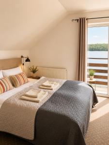 a bedroom with a bed with two towels on it at Sielanka nad Junem in Mrągowo