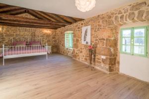 a room with stone walls and a bed and a wooden floor at Villa Garica in Garica +27 photos