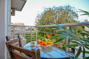 a table with a bowl of fruit on a balcony at Clio Apartment in Gázion