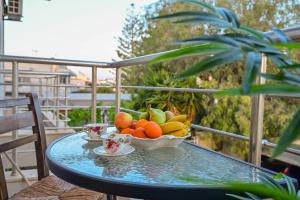 a bowl of fruit on a glass table on a balcony at Clio Apartment in Gázion