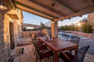 a wooden table and chairs on a patio with a pool at Villa Garica in Garica