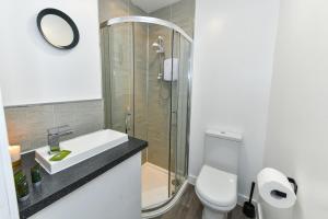 a bathroom with a shower and a sink and a toilet at Long Eaton Modern 4bed House in Long Eaton