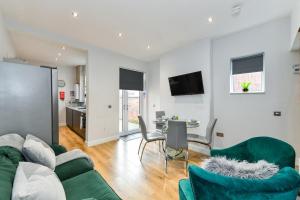 a living room with a green couch and a table at Long Eaton Modern 4bed House in Long Eaton