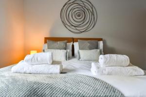 a bedroom with a bed with white towels on it at Long Eaton Modern 4bed House in Long Eaton