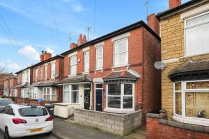 a white car parked in front of a brick building at 3-Bed Home Perfect for Exploring Nottingham & Derby in Long Eaton