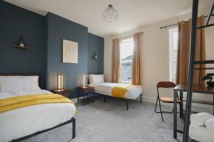 a hotel room with two beds and a chair at 3-Bed Home Perfect for Exploring Nottingham & Derby in Long Eaton