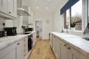 a kitchen with white cabinets and a counter top at 3-Bed Home Perfect for Exploring Nottingham & Derby in Long Eaton