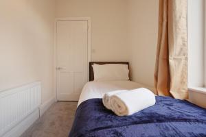 a bedroom with a bed with a towel on it at 3-Bed Home Perfect for Exploring Nottingham & Derby in Long Eaton +7 photos