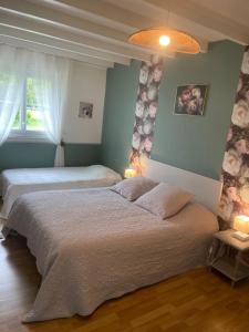 two beds in a bedroom with blue walls and two lamps at "Les Charmilles" - Maison de charme dans un ancien cloître in Sailly-Flibeaucourt