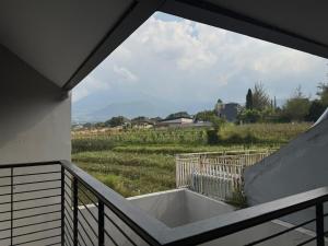 a bath tub on a balcony with a view of a field at Villa Grand Metro in Batu
