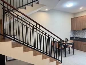 a staircase in a house with a table and chairs at Villa Grand Metro in Batu