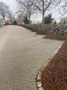 a street with a stone wall and a red car at 13min boxen, Legoland43min, MCH10min in Herning