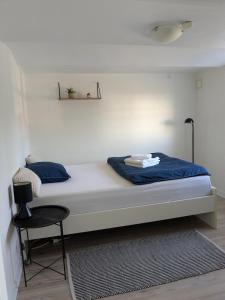 a bedroom with a bed with blue sheets and a chair at 13min boxen, Legoland43min, MCH10min in Herning