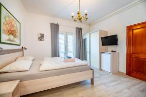 a bedroom with a bed and a flat screen tv at Bed & Breakfast Haus Lucija in Baška