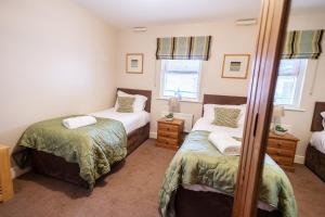 a bedroom with two beds and a mirror at Harbourside View Whitby in Whitby