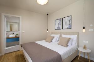 a bedroom with a large bed with white sheets and pillows at Villa Modrić by IstriaLux in Trviž +55 photos