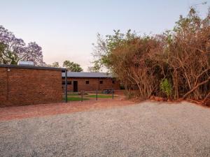 a brick building with trees in front of it at Nyala Lodge in Rayton +6 photos