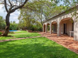 a yard with green grass and a building at Nyala Lodge in Rayton