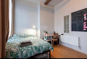 a bedroom with a bed and a table with a chalkboard at Raleigh Loft in Nottingham
