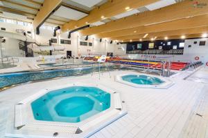 a large swimming pool with two jacuzzles in it at Tani skosik w MOSiRze in Sanok