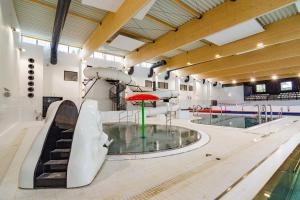 an indoor swimming pool with a slide and a swimming pool at Tani skosik w MOSiRze in Sanok +4 photos