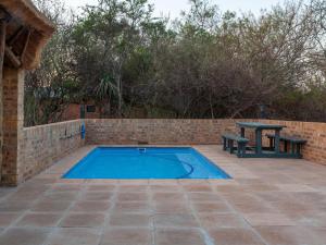 a swimming pool with a bench and a picnic table at Nyala Lodge in Rayton