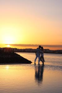 a couple kissing on the beach at sunset at Agua Hotels Riverside in Ferragudo