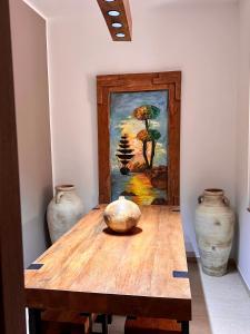 a table with two vases and a painting on the wall at Sweet Home in Ariana