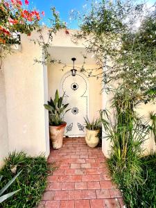 a patio with potted plants and a brick walkway at Sweet Home in Ariana