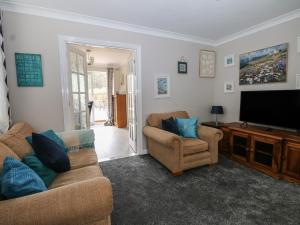 a living room with two couches and a flat screen tv at The Willows in Dymchurch