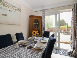 a dining room with a table and chairs and a window at The Willows in Dymchurch