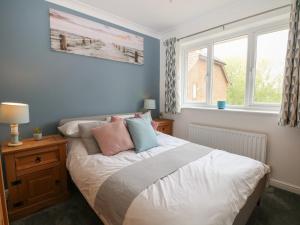 a bedroom with a bed with pillows and a window at The Willows in Dymchurch