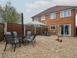 a patio with a table and chairs in front of a house at The Willows in Dymchurch