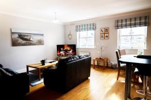 a living room with a couch and a fireplace at Harbourside View Whitby in Whitby