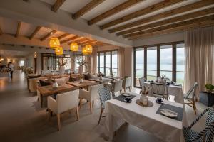 a restaurant with tables and chairs and windows at The Shark Bay Boutique Hotel & Spa in Langebaan