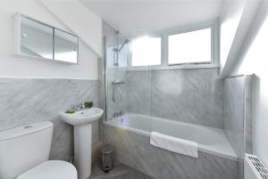 a bathroom with a tub and a toilet and a sink at Newark Central Cottage in Newark-on-Trent