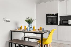 a kitchen with a table and yellow chairs at Stylish & Spacious Home in the Heart of Leeds in Central Station