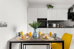 a kitchen with a table with plates of food on it at Stylish & Spacious Home in the Heart of Leeds in Central Station