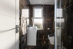 a bathroom with a toilet and a window at Stylish & Spacious Home in the Heart of Leeds in Central Station