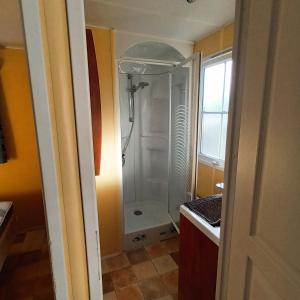 a bathroom with a shower with a glass door at Camping Baroudeurs in Lagraulière +20 photos