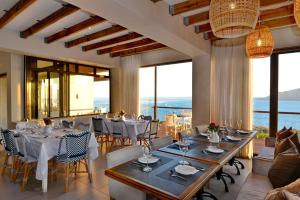 a dining room with tables and chairs and windows at The Shark Bay Boutique Hotel & Spa in Langebaan
