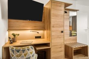 a room with a desk and a tv on a wall at Colleen Apartments Wesertal in Porta Westfalica +107 photos