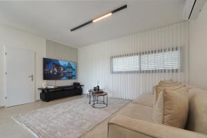 a living room with a couch and a table at taira suite in Rosh Pinna