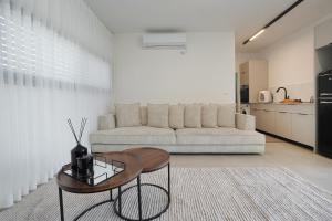 a living room with a couch and a table at taira suite in Rosh Pinna