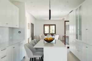 a kitchen with a table with a bowl of fruit on it at Mountain view 6 bed mansion with Private Padel Court, Pool & Gym in Larnaca