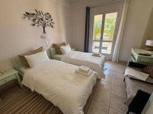 a room with two beds and a couch and a window at Sirios in Acharavi