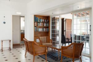 a living room with a table and chairs and a book shelf at Mountain view 6 bed mansion with Private Padel Court, Pool & Gym in Larnaca