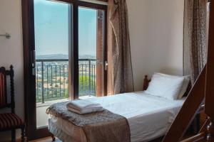 a bedroom with a bed and a large window at Mountain view 6 bed mansion with Private Padel Court, Pool & Gym in Larnaca +53 photos