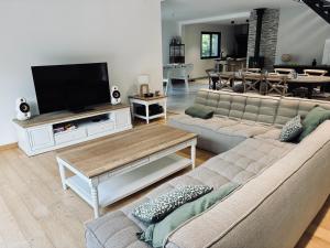 a living room with two couches and a flat screen tv at villa des gorges in Vagnas